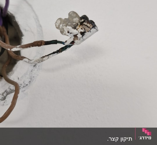 חוטי חשמל חשופים יוצאים מקיר לבן